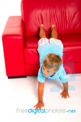 Boy On Red Sofa Stock Photo