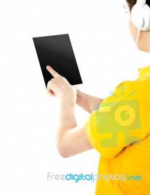 Boy pressing Ipad with headphones  Stock Photo