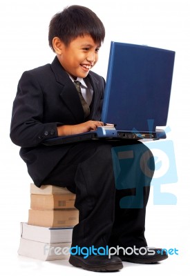 Boy Sitting On A Pile Of Books Stock Photo