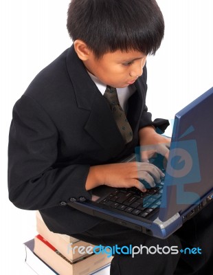 Boy Sitting On A Pile Of Books Stock Photo