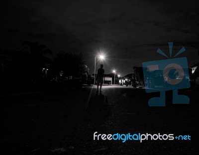 Boy Walking Alone At Night Under The Street Lights Stock Photo