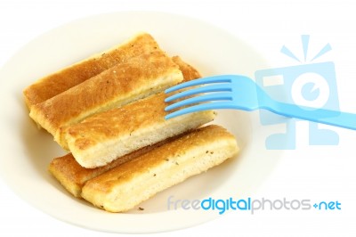 Bread Stick In White Disk With Blue Plastic Fork Stock Photo