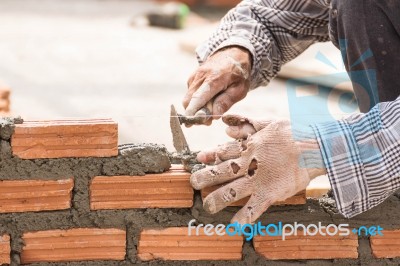 Bricklayer Working In Construction Site Of A Brick Wall Stock Photo