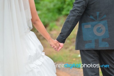 Bride And Groom Walking Away On The Road Stock Photo