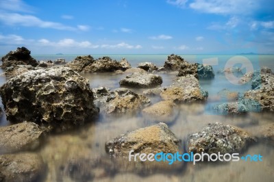 Brown Rock On Blue Sea Stock Photo