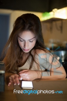 Brunette In Kitchen With Mobile Phone Stock Photo