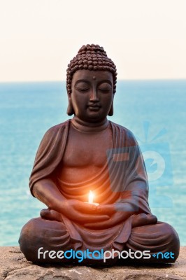 Buddha With A Candle In Hands Stock Photo