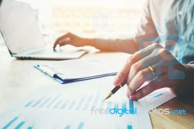 Business Man Holding Pen Pointing On Summary Report Chart Stock Photo