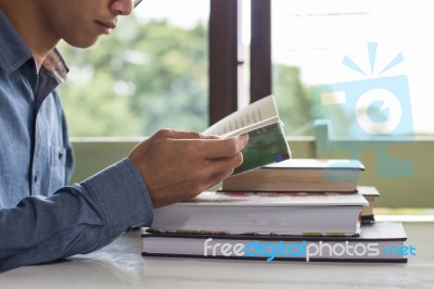 Business Man Sitting At A Table Reading A Book Stock Photo