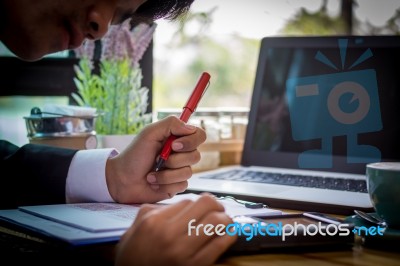 Business Man Sitting On A Calculator To Figure Out In A Coffee S… Stock Photo