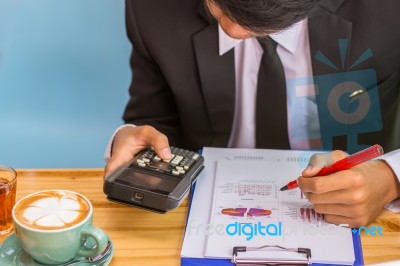 Business Man Sitting On A Calculator To Figure Out In A Coffee S… Stock Photo