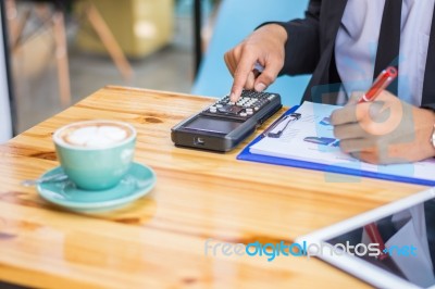 Business Man Sitting On A Calculator To Figure Out In A Coffee S… Stock Photo