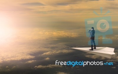 Business Man Standing And Spying Binocular On Papet Plane Agains… Stock Photo