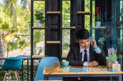 Business Man Using Mobile Phone While Sitting In The Coffee Shop… Stock Photo