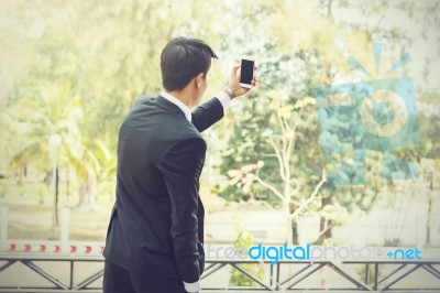 Business Man Using Mobile Phone While Standing On The Balcony In… Stock Photo