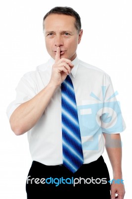 Business Man With Finger On Lips Asking For Silence Stock Photo