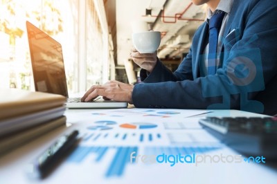 Business Man Working At Office With Laptop, Tablet And Graph Dat… Stock Photo