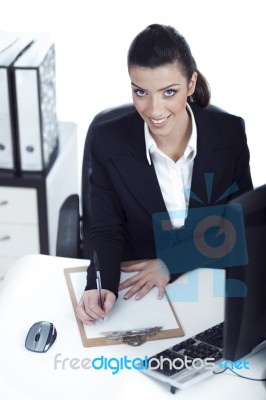 Business Woman Making Notes And Looking At The Camera Up Stock Photo