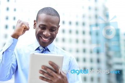 Businessman Celebrates His Success With Tablet Stock Photo