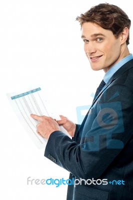 Businessman Cross-checking Annual Report Stock Photo