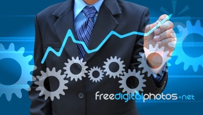 Businessman Hand Drawing Business Graph And Cog Gear Stock Photo