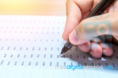 Businessman Hand Holding A Pen Working On Document Stock Photo