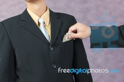 Businessman Hand Put Money To Pocket Stock Photo