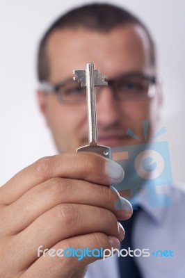 Businessman Handing Over A Key To You Stock Photo