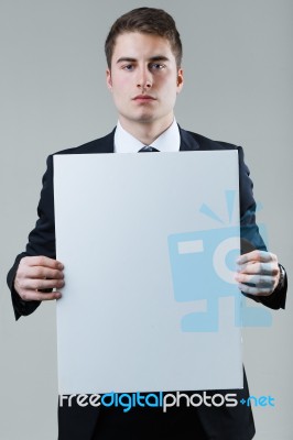 Businessman Holding Empty White Placard Showing Copy Space Stock Photo