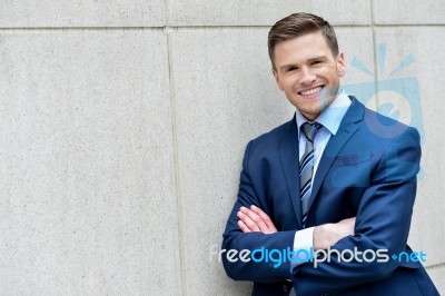 Businessman Leaning Against A Concrete Wall Stock Photo