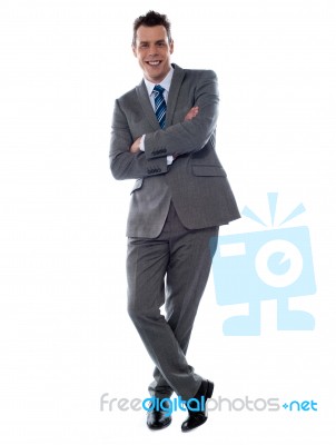 Businessman Leaning Against Wall Stock Photo