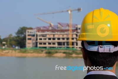 Businessman Looking At Building With Crane Stock Photo