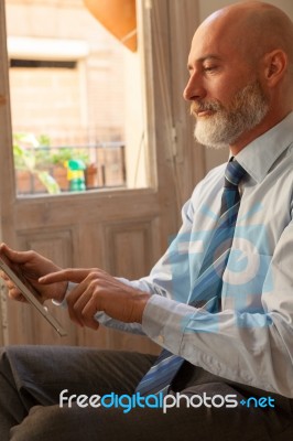 Businessman Middle-aged Working From Home With A Tablet Stock Photo