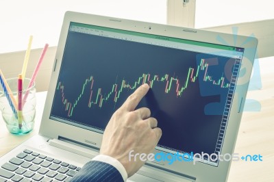 Businessman Point And Analyze Forex Graph Or Stock Graph By Right Finger On Blue Vintage Style Stock Photo