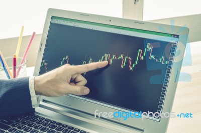 Businessman Point And Analyze Forex Graph Or Stock Graph On Blue Vintage Style Stock Photo