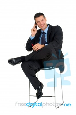 Businessman Sat Talking On Mobile Phone Stock Photo