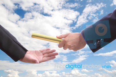 Businessman Send Golden Baton To Another One Stock Photo