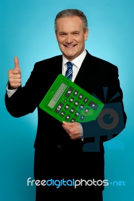 Businessman Showing Thumbs Up, Holding Calculator Stock Photo