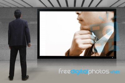 Businessman Standing Looking At The Tv Screen Stock Photo