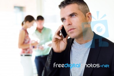 Businessman Talking On Mobile Phone In Office Stock Photo