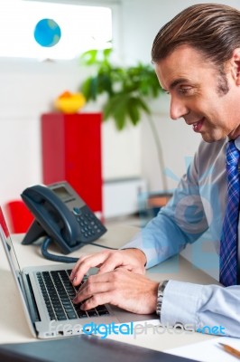 Businessman Typing Report On A Laptop Stock Photo