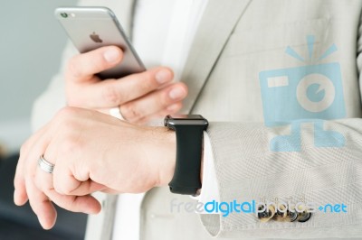 Businessman Using The Apple Watch And An Apple Iphone 6 Stock Photo