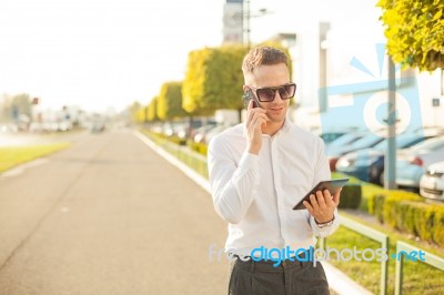 Businessman With Mobile Phone And Tablet In Hands Stock Photo