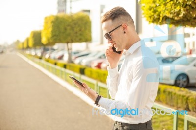 Businessman With Mobile Phone And Tablet In Hands Stock Photo