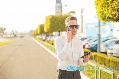 Businessman With Mobile Phone And Tablet In Hands Stock Photo