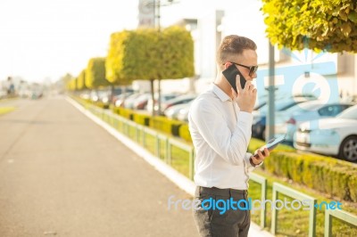 Businessman With Mobile Phone And Tablet In Hands Stock Photo