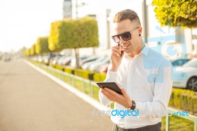 Businessman With Mobile Phone And Tablet In Hands Stock Photo