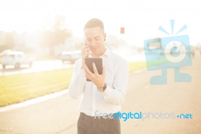 Businessman With Mobile Phone Tablet In Hands Stock Photo