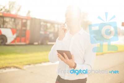 Businessman With Mobile Phone Tablet In Hands Stock Photo