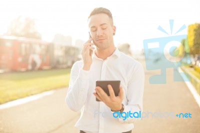 Businessman With Mobile Phone Tablet In Hands Stock Photo